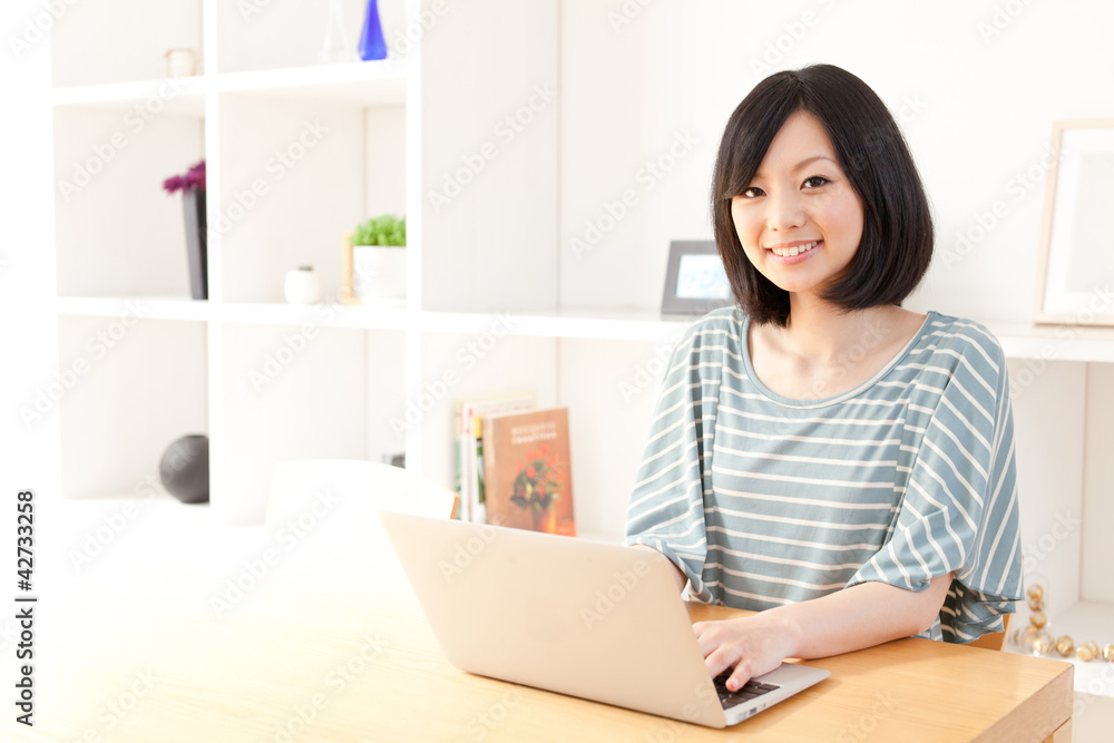一位使用笔记本电脑的年轻亚洲女性