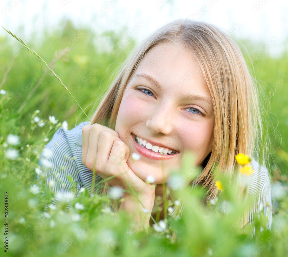 微笑的女孩在户外放松。草地