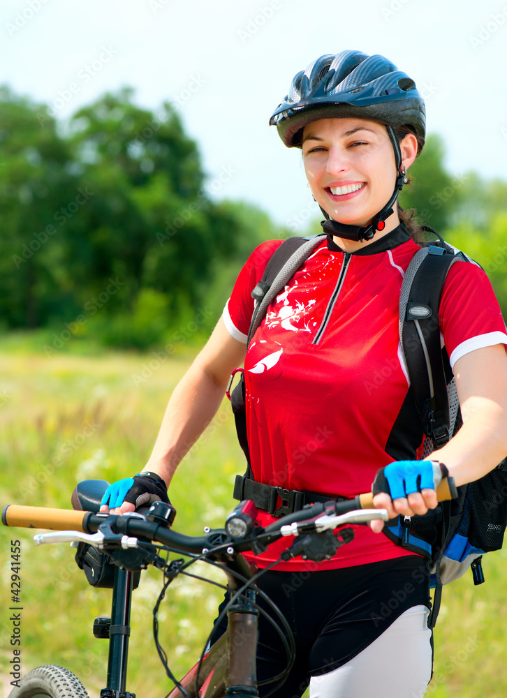 快乐的年轻女人在外面骑自行车。健康的生活方式