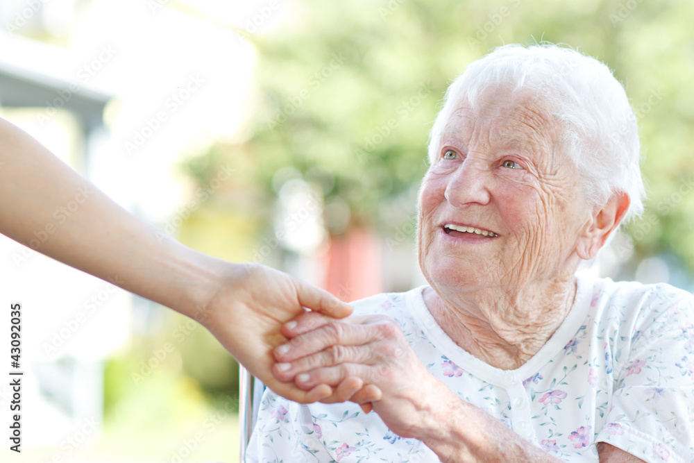 老年妇女与看护人牵手