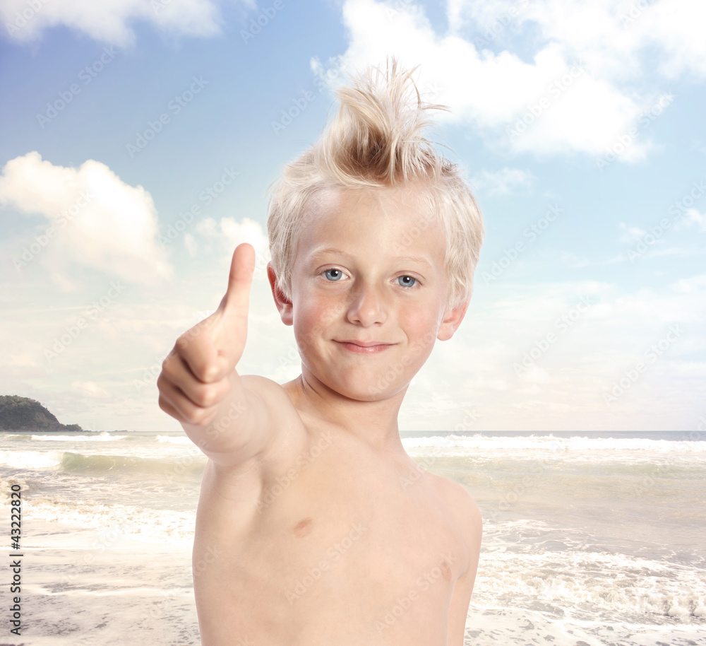 金发男孩在海滩竖起大拇指