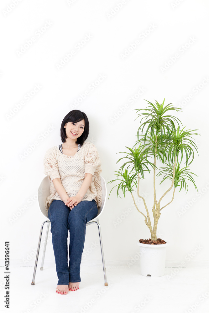 一个年轻的亚洲女人坐在椅子上