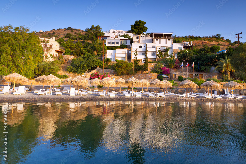 希腊克里特岛米拉贝洛湾带遮阳伞的日光浴床