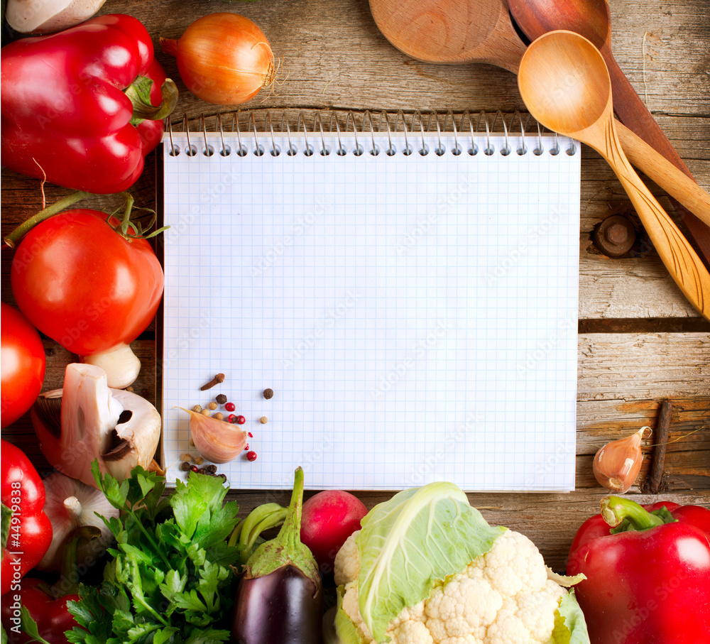 打开笔记本和新鲜蔬菜背景。饮食