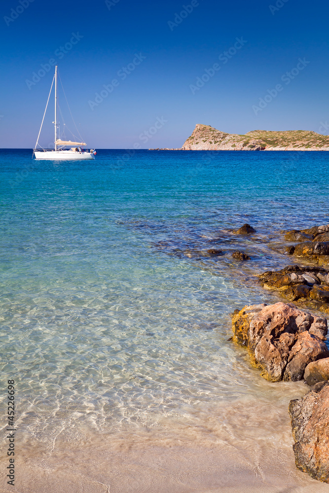 希腊克里特岛田园诗般的海滩泻湖上的白色游艇