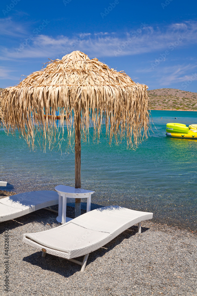 希腊爱琴海遮阳伞下的躺椅
