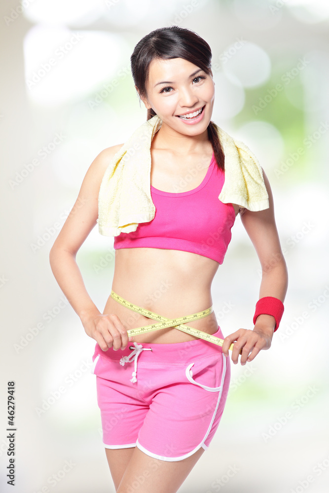 Woman smile measuring waist after sport