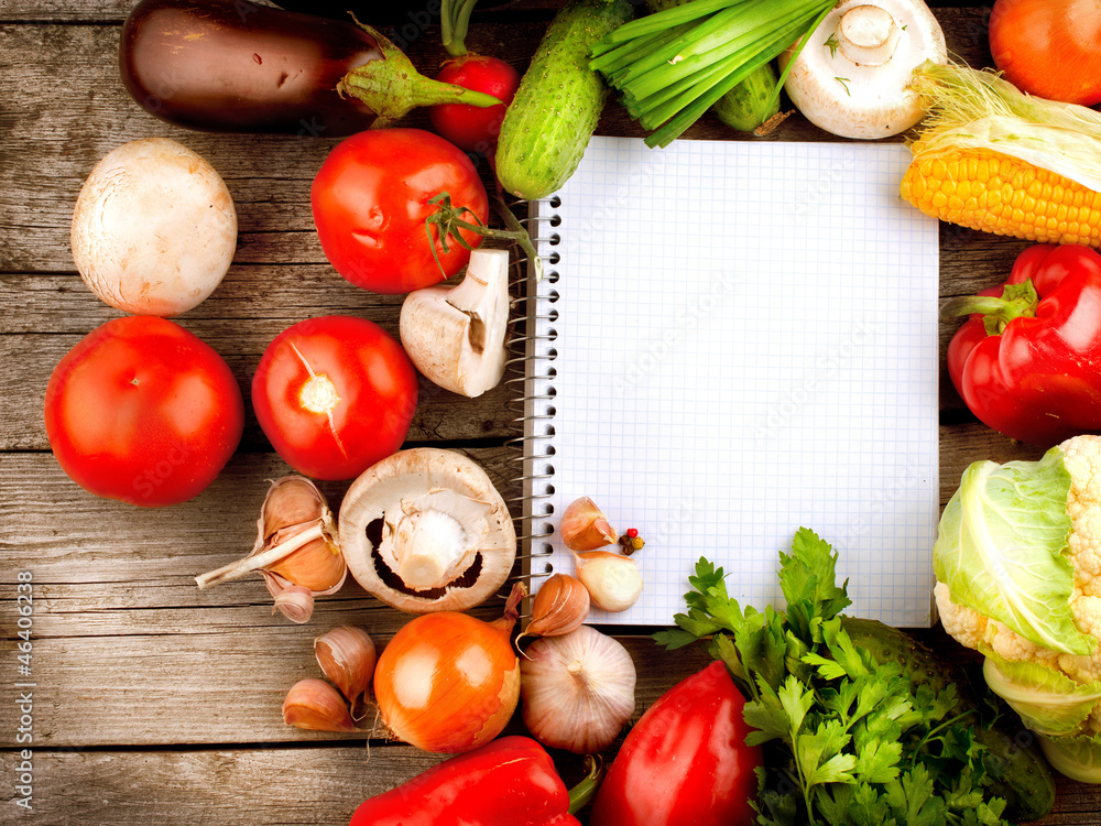 打开笔记本和新鲜蔬菜背景。饮食