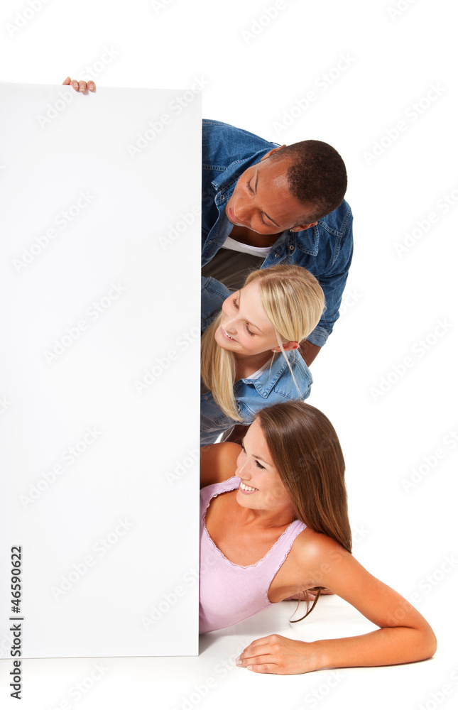 Drei attraktive junge Personen schauen auf weißen Platzhalter