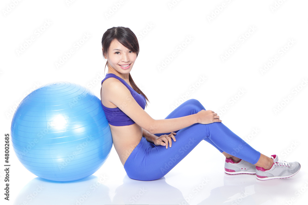 快乐女人坐在地板上健身球