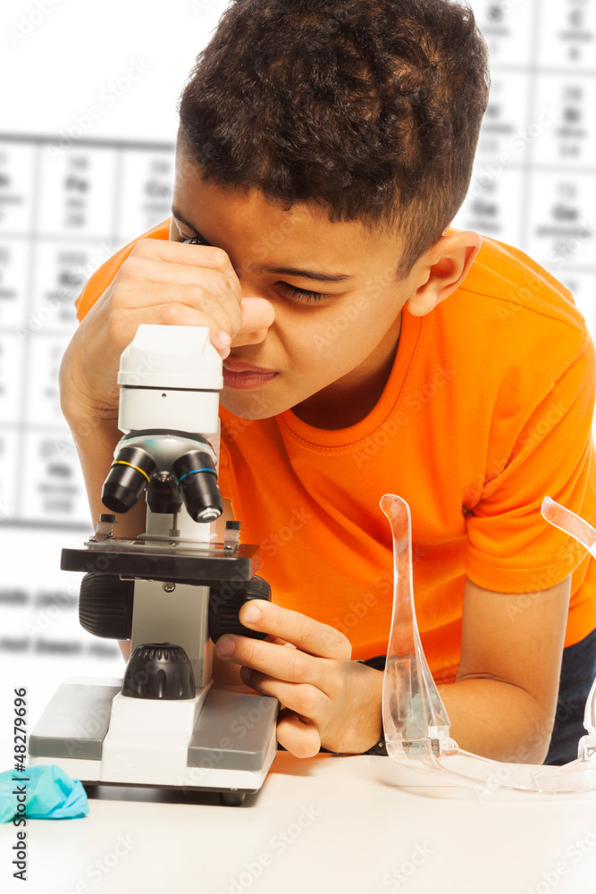 黑人男孩在显微镜下看