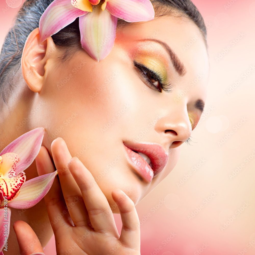 Beautiful Spa Girl With Orchid Flowers Touching her Face