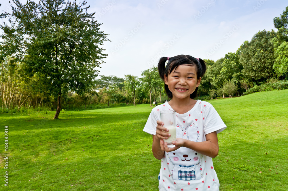 户外草坪抱着牛奶非常快乐的亚洲女孩
