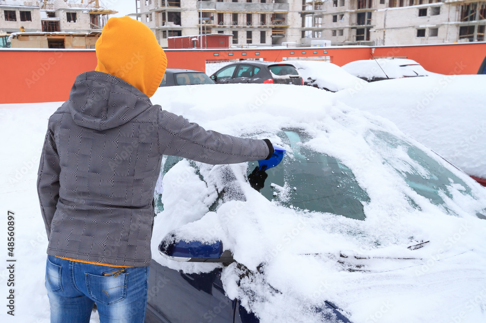 冬天女人从车窗刮冰
