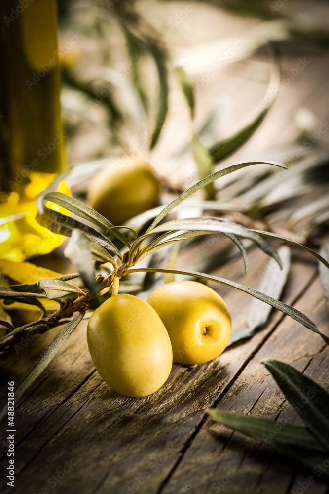 木桌上的有机橄榄和一瓶油。