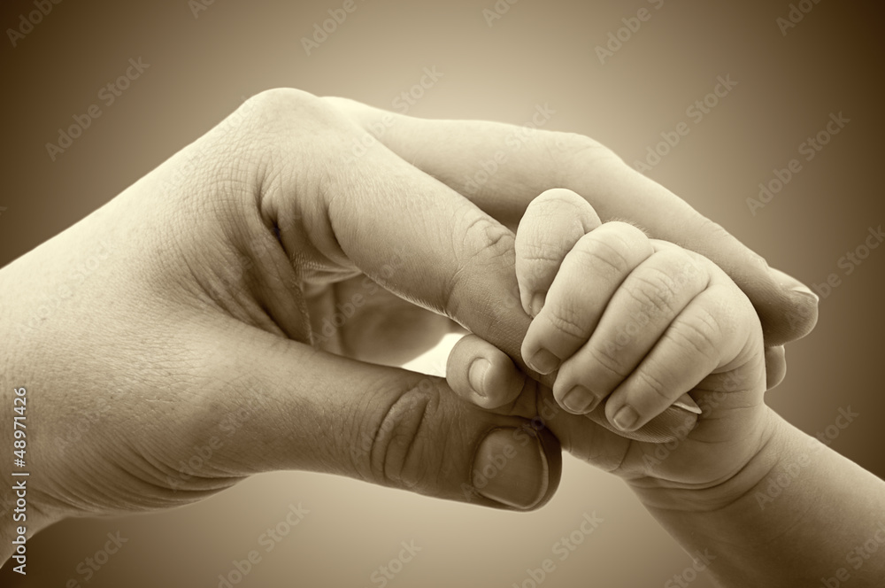 爱和家庭的概念。母亲和婴儿的手