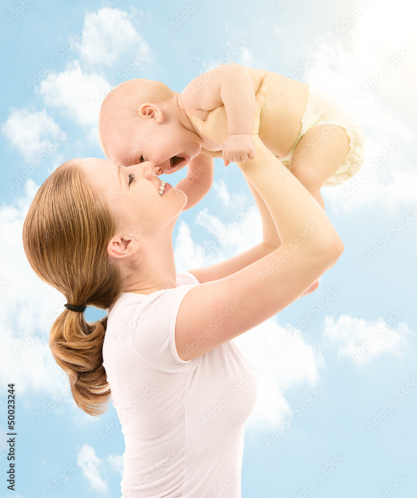 happy family. Mother kissing baby in the sky