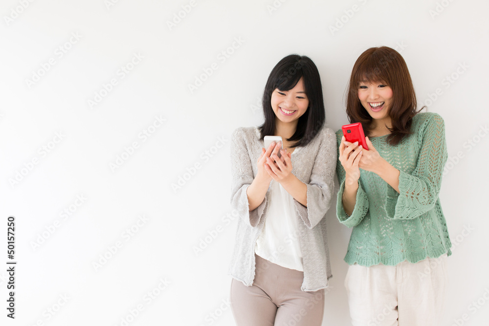 有魅力的亚洲女性在房间里使用智能手机