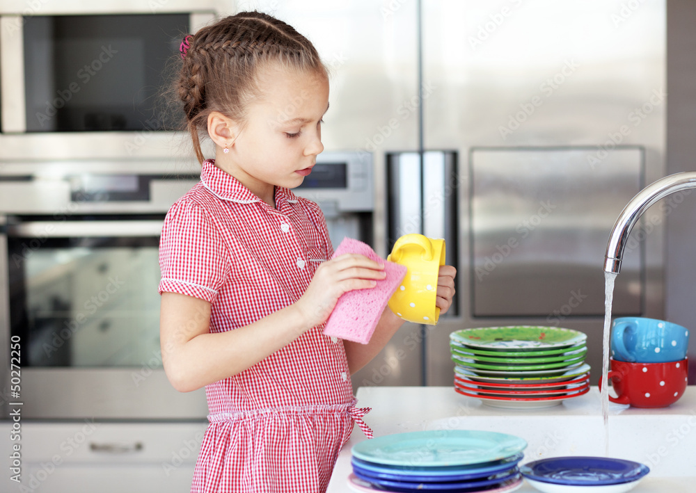 Little girl washing the dishes