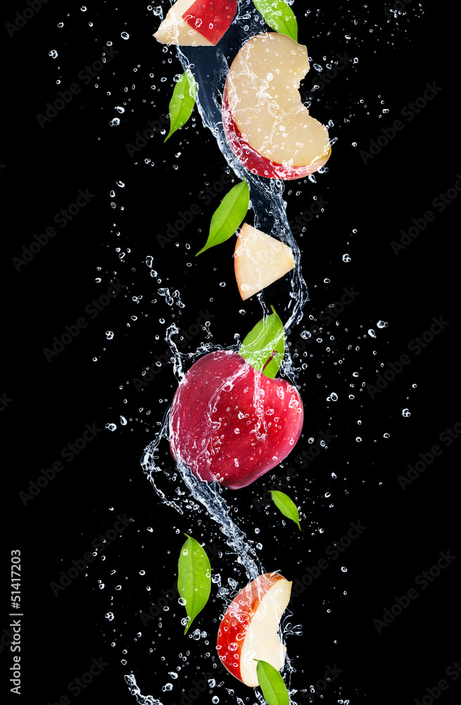 Red apples in water splash, isolated on black background