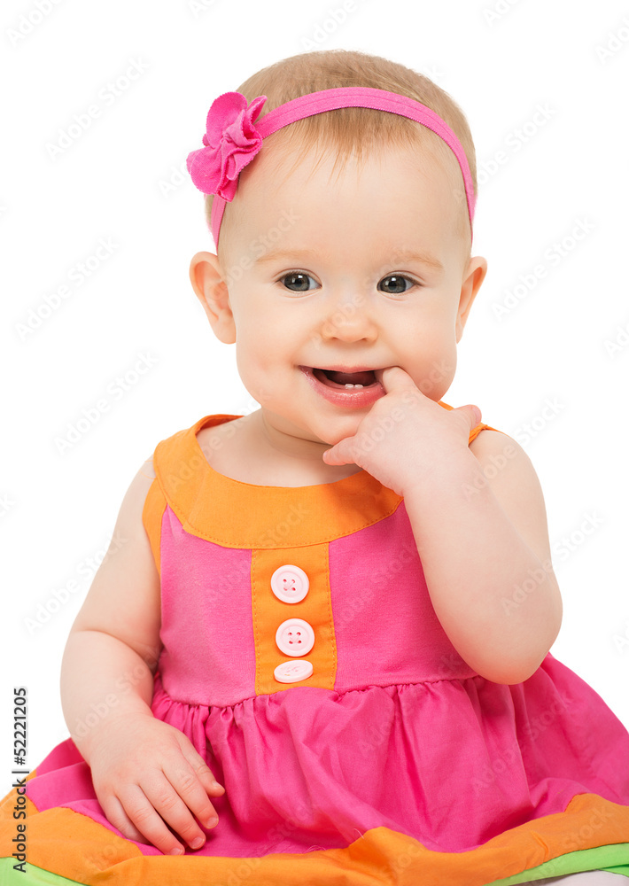 穿着鲜艳多彩的节日连衣裙的快乐狡猾的小女婴
