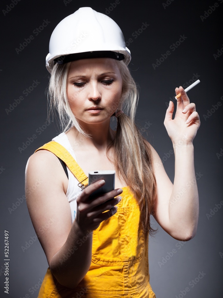 年轻的建筑师，女建筑工人，香烟和电话