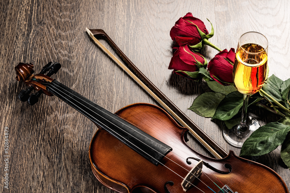 小提琴、玫瑰、一杯香槟和音乐书籍