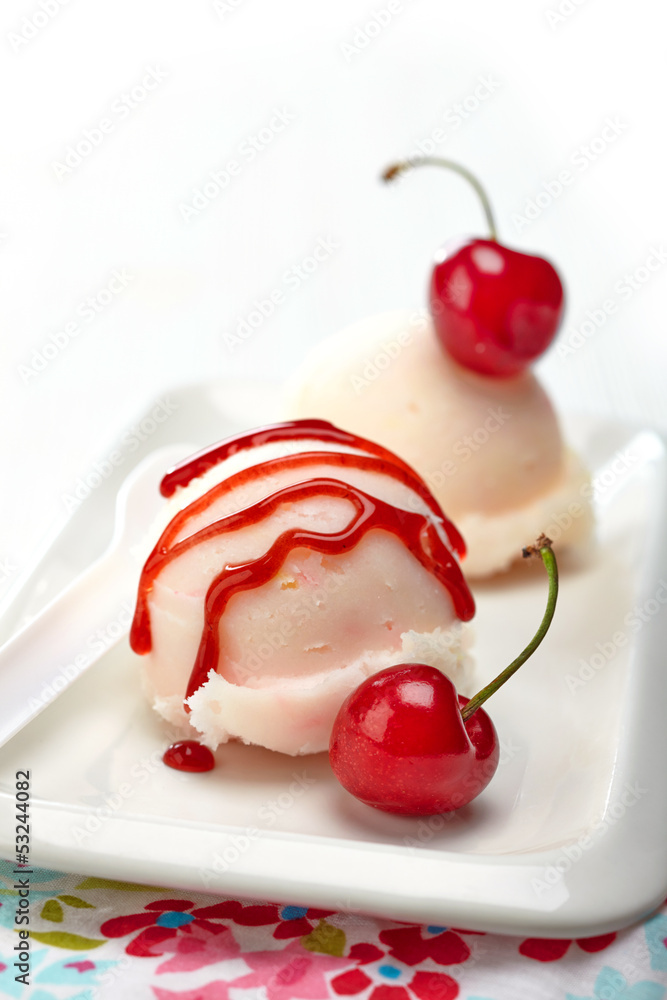 closeup of icecream scoop with sweet sauce and cherry