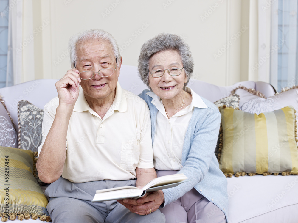 一对亚洲高级夫妇拿着一本书微笑着