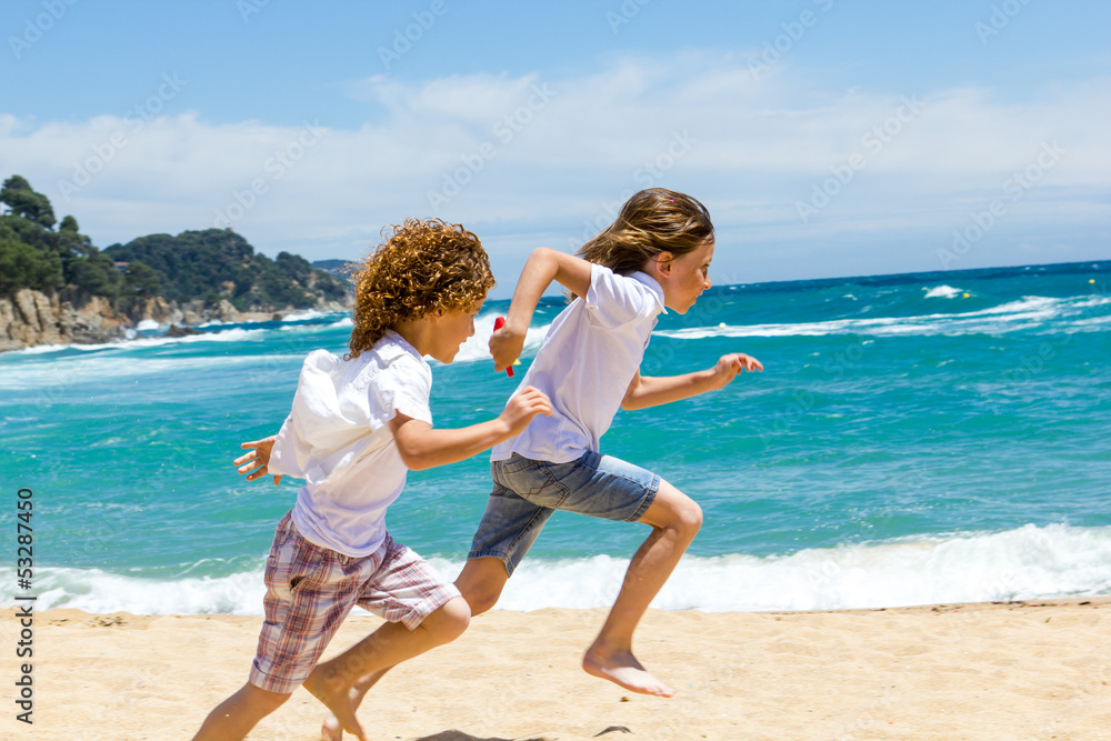 两个男孩在海滩上奔跑。