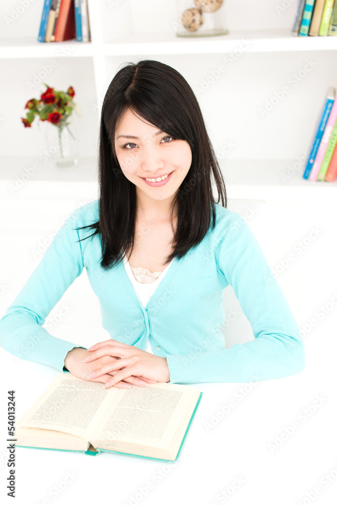 有魅力的亚洲女人在房间里看书
