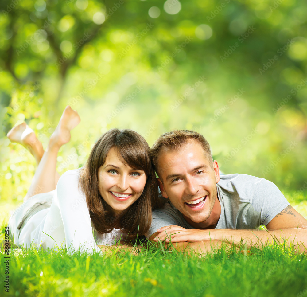 幸福的微笑情侣在户外绿草上放松