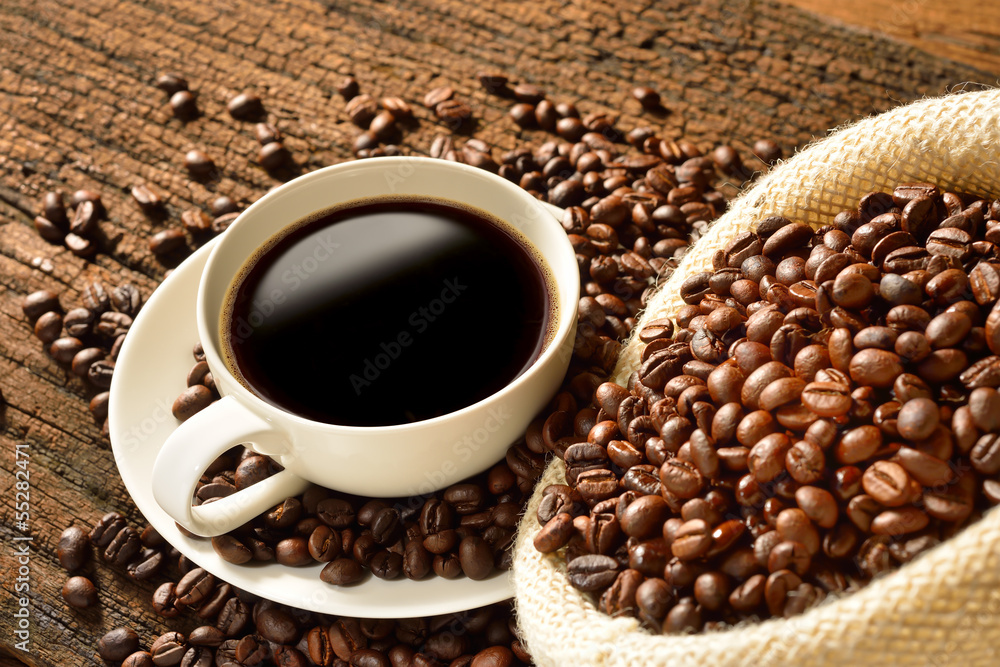 旧木背景的咖啡杯和咖啡豆