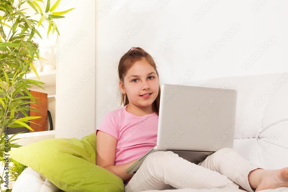 拿着笔记本电脑的女孩坐在沙发上