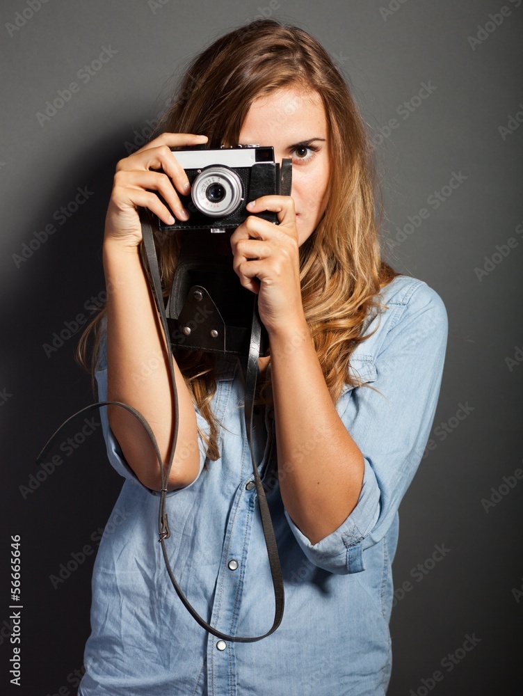 Photographer in jeans jacket taking pictures with old camera
