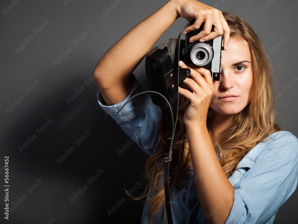 年轻摄影师穿着牛仔夹克，带着旧相机