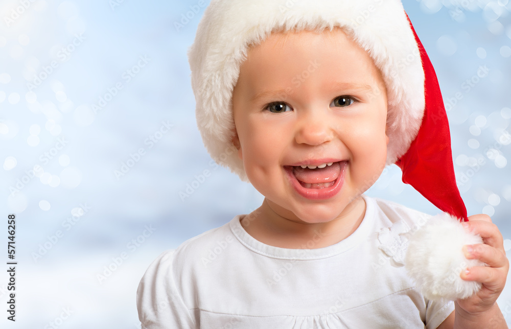 Beautiful funny baby in a Christmas hat  on blue
