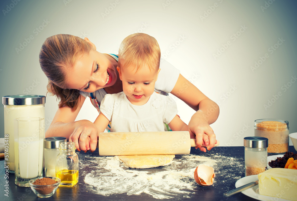 女婴和她的妈妈一起做饭，烤面包