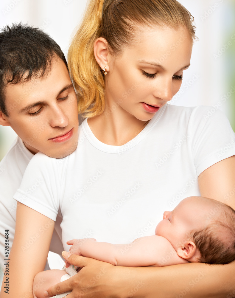 happy young family of mother, father and newborn baby in their a