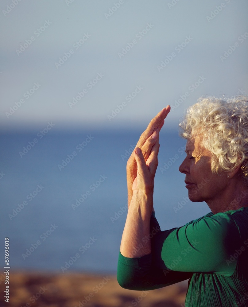 在海边锻炼的白人老年妇女