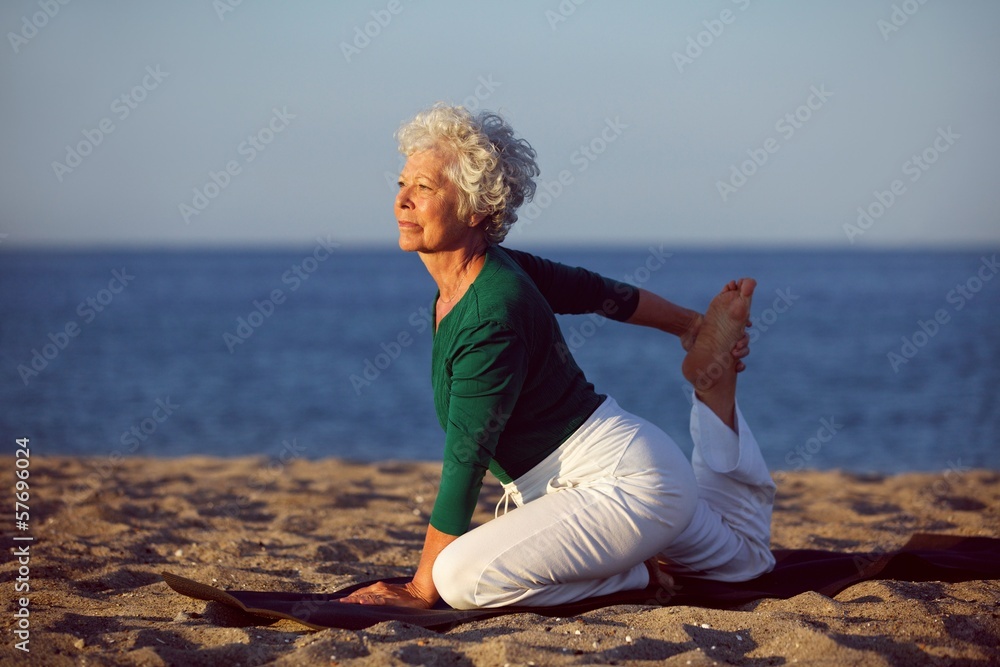 在海边做瑜伽的资深女性