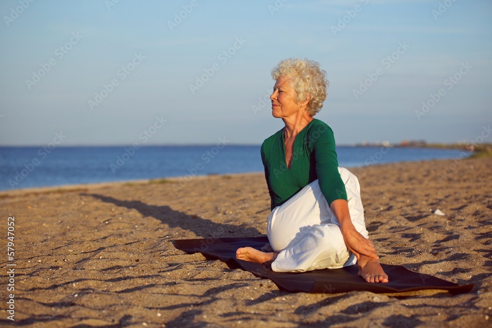 老年妇女在海滩上做瑜伽