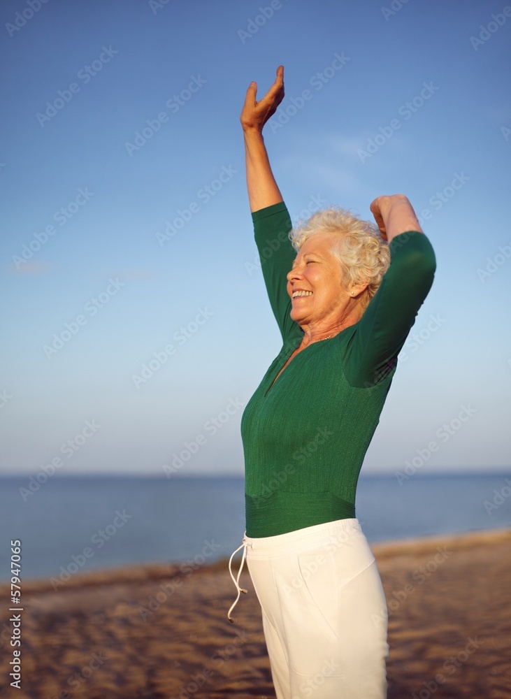 健康的成熟女性在海滩上练习瑜伽