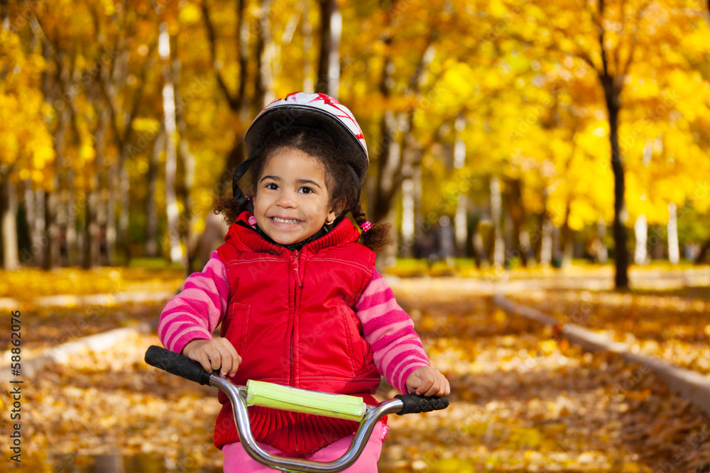 骑在自行车上微笑的小女孩