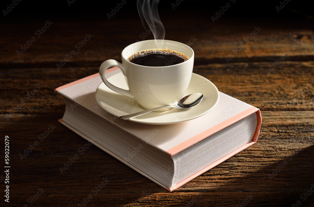 一杯咖啡放在一个像书一样的盒子上。