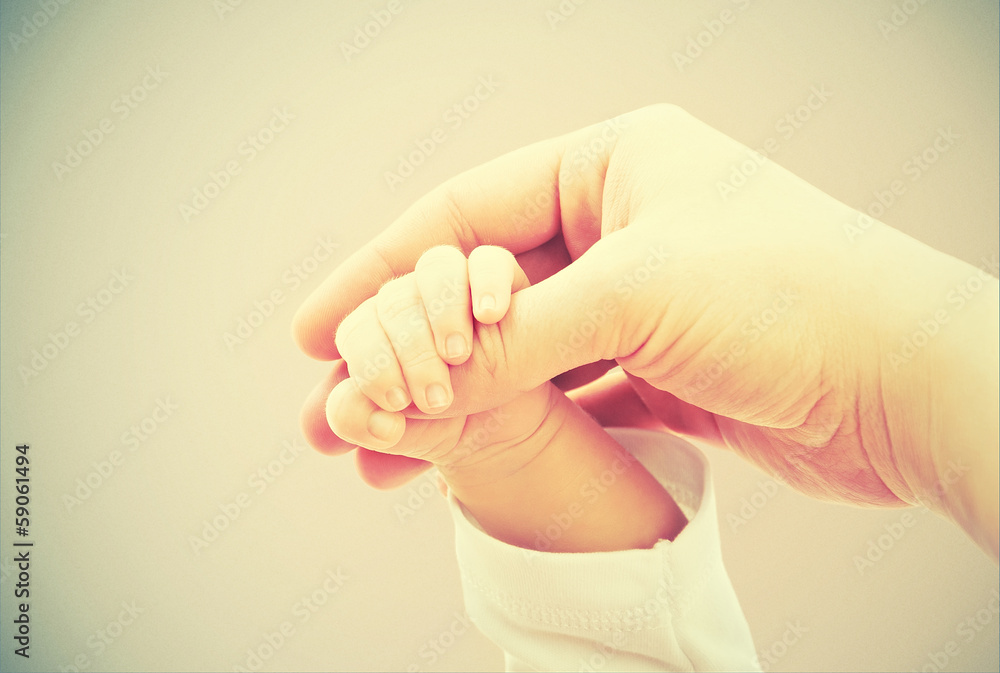 爱和家庭的概念。母亲和婴儿的双手