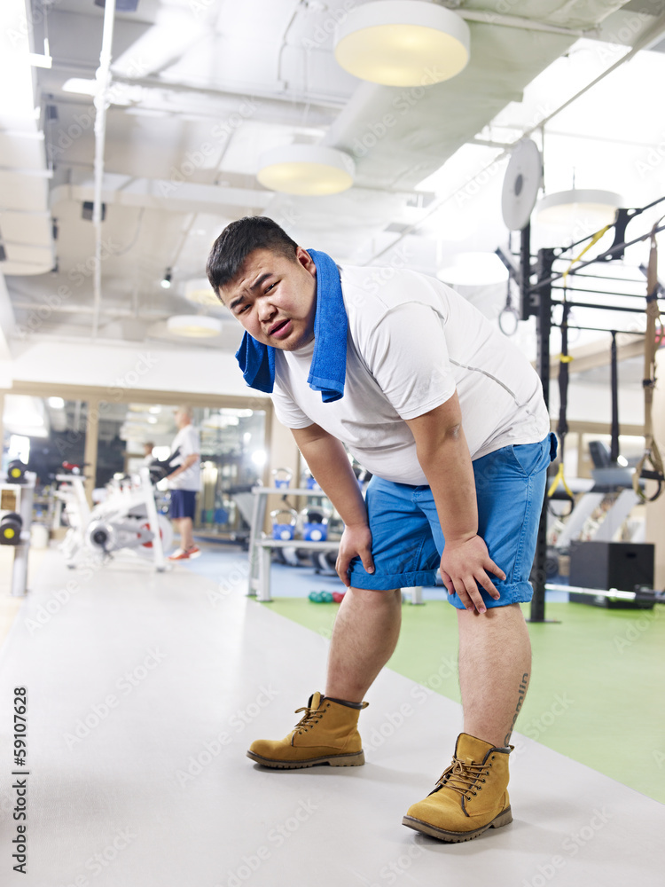 exhausted overweight man in gym