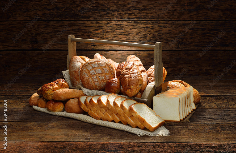 篮子里的各种面包，背景是古老的木制。