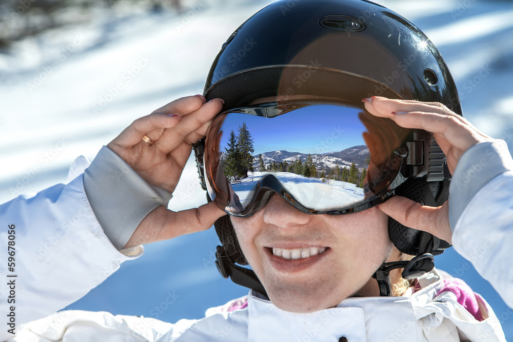 戴着护目镜和头盔的女人待在雪地上