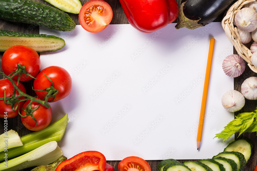 Vegetables tiled around a sheet of paper